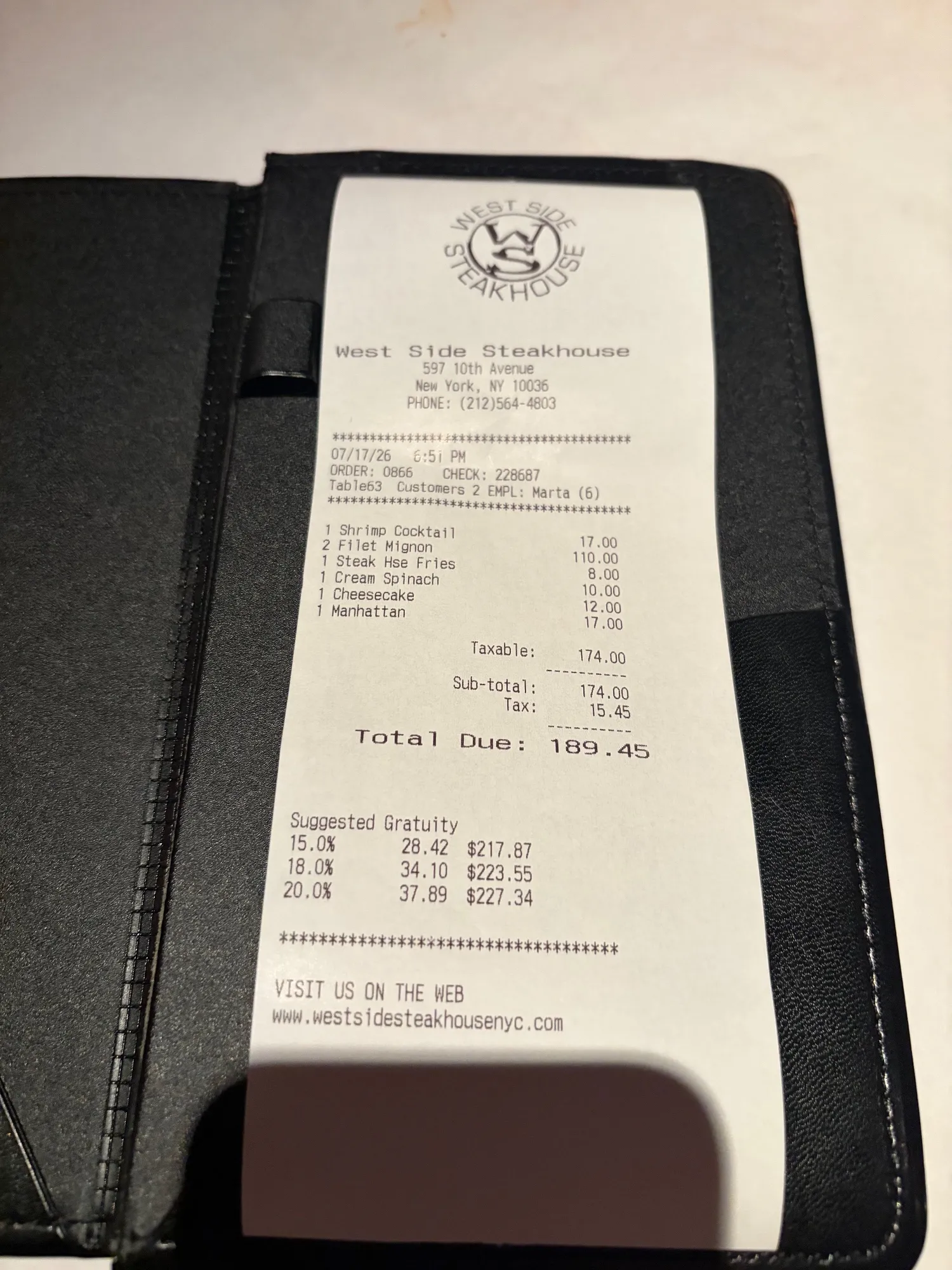 A West Side Steakhouse receipt listing shrimp cocktail, filet mignon, steak-house fries, creamed spinach, cheesecake and a Manhattan, with a $189.45 total.